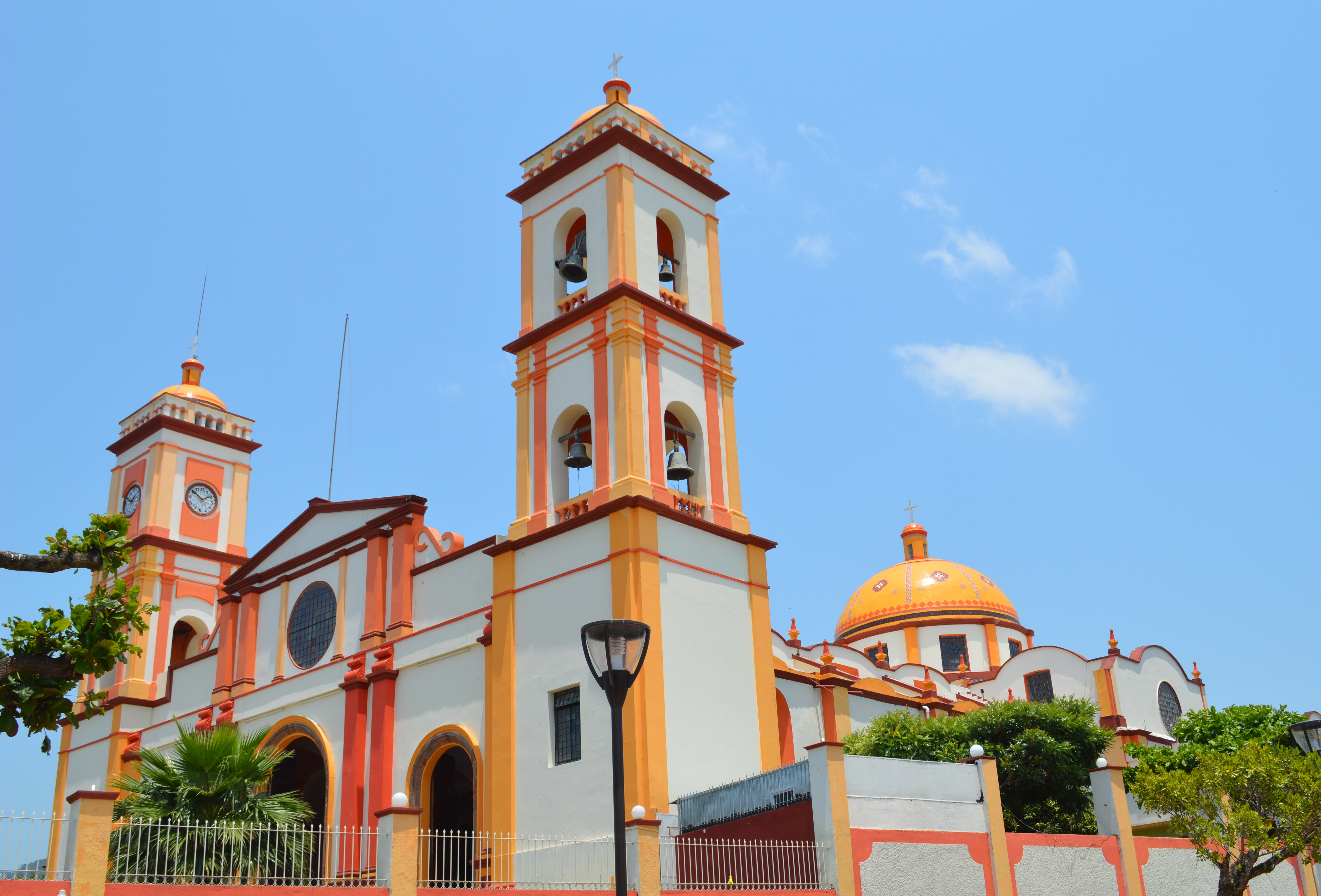 Tres jóvenes de San Andrés Tuxtla sonríen frente al kiosco del zócalo; la joven al centro muestra la credencial del programa Juventud San Andrés.